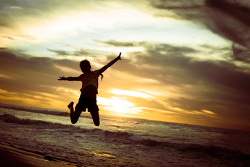 Poster - Happy girl jumping on the beach on the dawn time