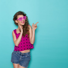 Smiling Girl In Heart Shaped Glasses Pointing