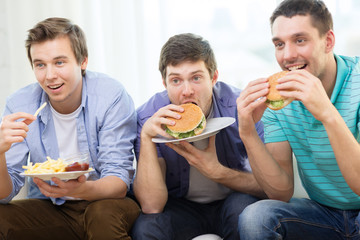 Poster - smiling friends with soda and hamburgers at home