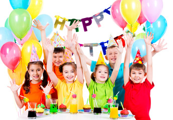 Group of children at the birthday party with raised hands.