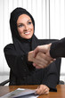 Arabic business woman shaking hands with customer.