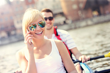 Poster - Young woman talking on the phone in a canoe