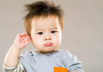 confused baby boy hand touch ear