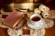 © narstudio - Cup of tea, book and glasses on old wooden table.