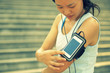 © lzf - woman runner listening to music in headphones from smart phone