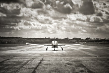 Sepia Toned Light Aircraft Take-off Into Dark Clouds