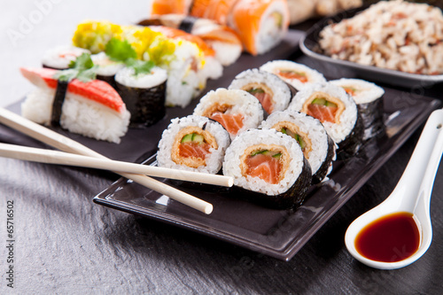 Naklejka samoprzylepna Pyszne kawałki sushi podawane na czarnym kamieniu