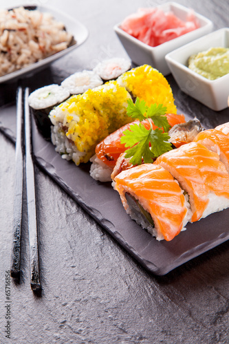 Naklejka samoprzylepna Pyszne kawałki sushi podawane na czarnym kamieniu