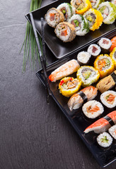 Canvas Print - Delicious sushi pieces served on black stone