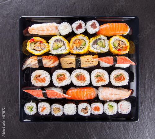 Fotoboard na płycie Pyszne kawałki sushi podawane na czarnym kamieniu