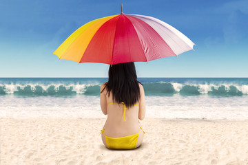 Wall Mural - Rearview of woman under umbrella