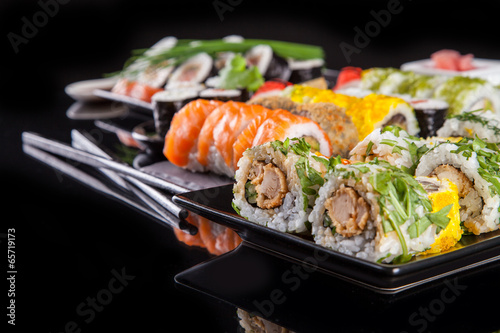 Fotoboard na płycie Pyszne kawałki sushi na czarnym tle