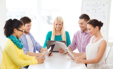 Wall Mural - smiling team with table pc and laptop in office