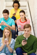 © Syda Productions - busy students with smartphones sitting on stairs