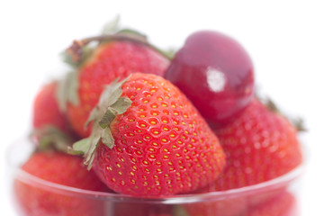 Wall Mural - Cherries and strawberry in a glass bowl isolated on white