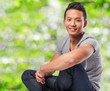 © asierromero - handsome young asian man sitting at park