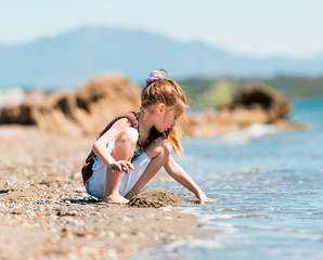 little girl builds a tower of sand