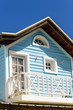 Wooden bright blue wooden house with white windows and balcony