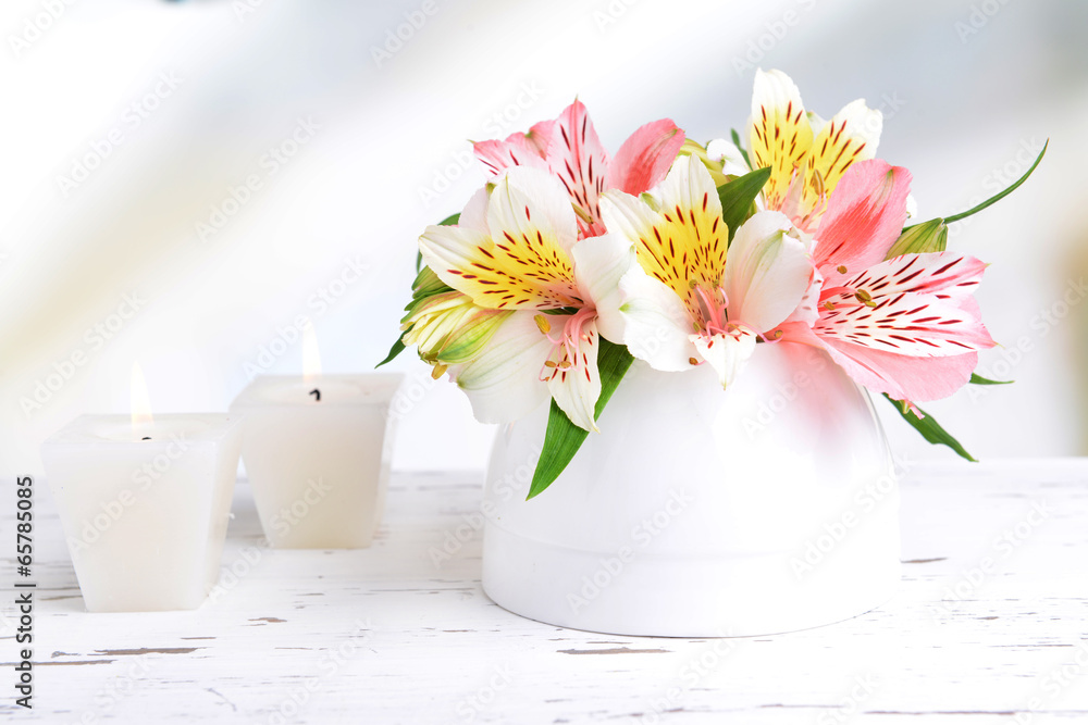 Alstroemeria flowers in vase on table on light background