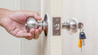 Hand holding door knob with keys