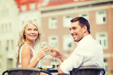 Wall Mural - smiling couple drinking wine in cafe