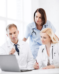 Wall Mural - doctors looking at laptop on meeting