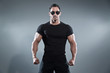 © ysbrandcosijn - Combat muscled action hero man wearing black t-shirt with pants