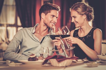 Wall Mural - Couple with glasses of red wine in luxury restaurant