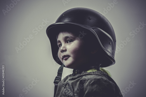 Fotografia fun and funny child dressed in military cap, playing war games