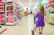 © travnikovstudio - Back view of fashion girl with trolley in kid shopping center
