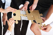 © Robert Przybysz - Stalowe puzzle.Grupa ludzi prezentuje srebrno złote puzzle
