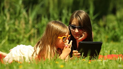 Wall Mural - Picnic. Mother with daughter using tablet outdoor