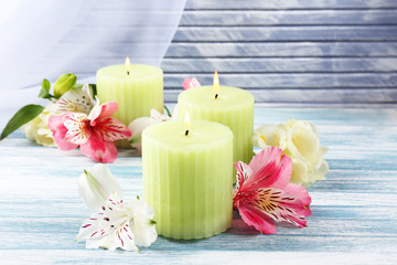 Wall Mural - Beautiful candles with flowers on wooden background