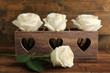 Beautiful white roses in decorative box on wooden table