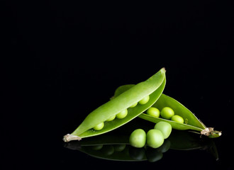 Fresh green peas isolated on black background