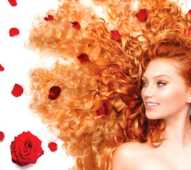 Wall Mural - Beauty girl with long curly red hair and beautiful red roses