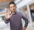young asian man doing stop gesture with hand