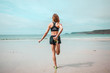 © LoloStock - Young woman stretching her leg on beach