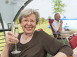 © GordonGrand - Senior Woman Outdoors in the Summer with Glass of Champagne