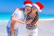 © travnikovstudio - Portrait of young couple in Santa hats enjoy beach vacation