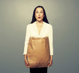 Wall Mural - amazed young woman holding paper bag