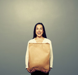 Wall Mural - happy girl with paper bag over dark