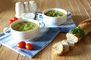 Canvas Print - Tasty soup in saucepans on wooden table, close up