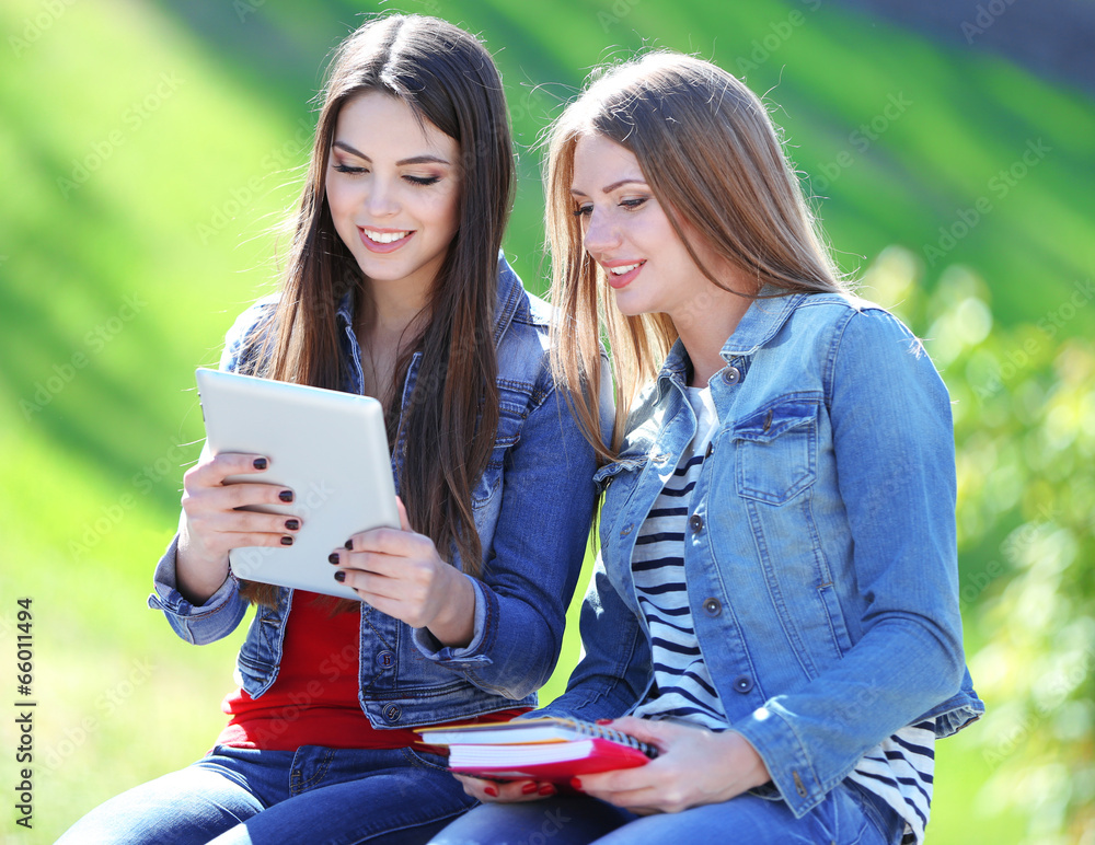 Happy students sitting in park