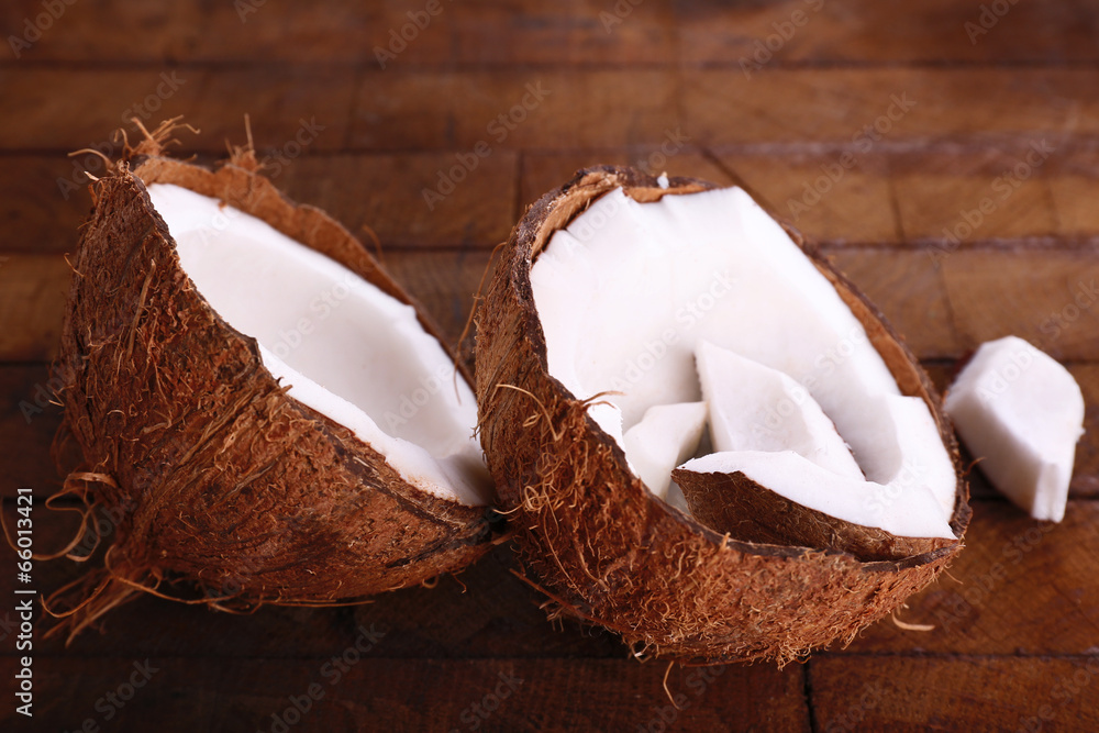 Broken coconut on wooden background