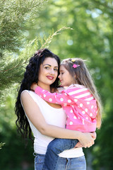 Wall Mural - Happy mom and daughter. Walk in the green park