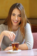 © Antonioguillem - Happy woman in a coffee shop with a cup of tea