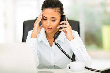 confused office worker talking on telephone