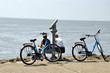 Eine Fahrradpause an der Nordsee und auf das offene Meer schauen. Zwei Frauen sitzen am Ufer  mit ihren Fahrrädern 