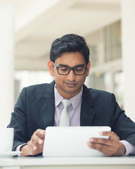 Wall Mural - young indian business man with a tablet computer and coffee at a